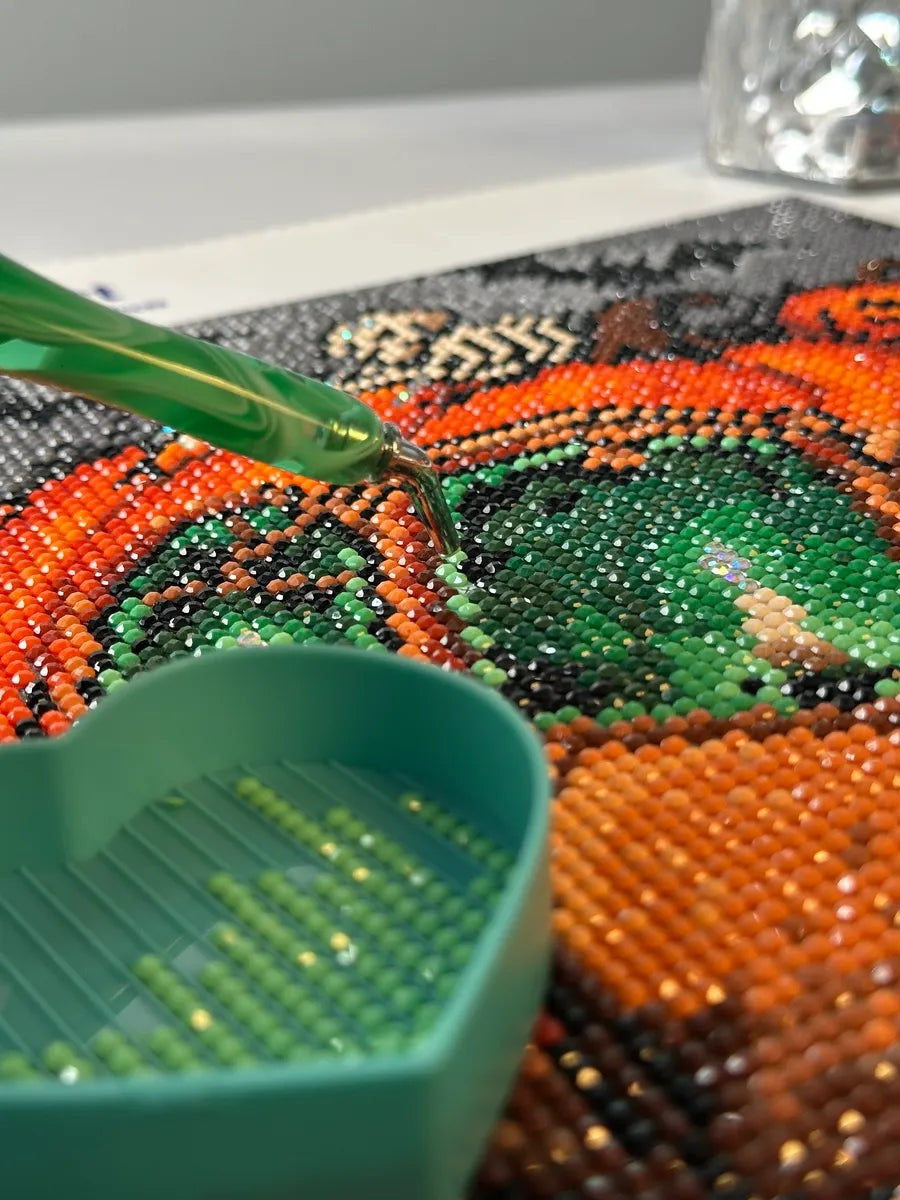 A diamond art canvas with glowing pumpkins and drills in progress under warm Halloween lighting - FEELOOK Art