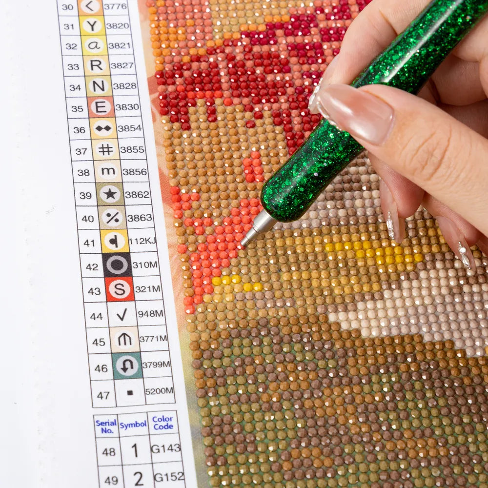 Hand placing drills on a diamond painting canvas beside a clear symbol chart - FEELOOK Art