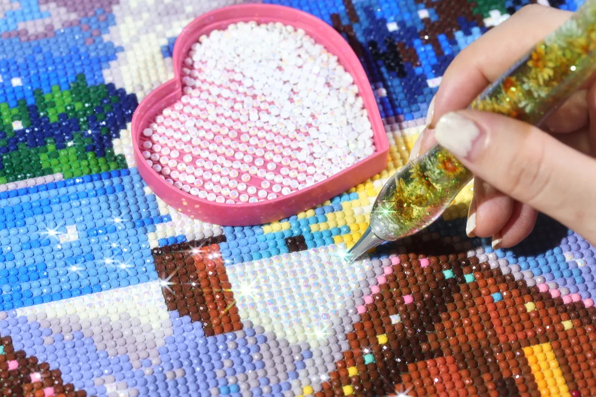 Diamond painting in progress with a hand placing colorful resin drills onto a canvas, showing a close-up of a partially completed artwork with vibrant details and a textured pattern forming - FEELOOK Art