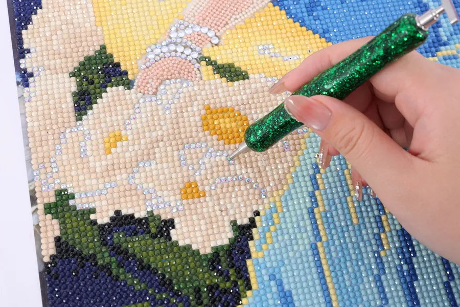 Hand placing resin drills on Selene diamond painting, revealing a white flower with soft blue and yellow details - FEELOOK Art