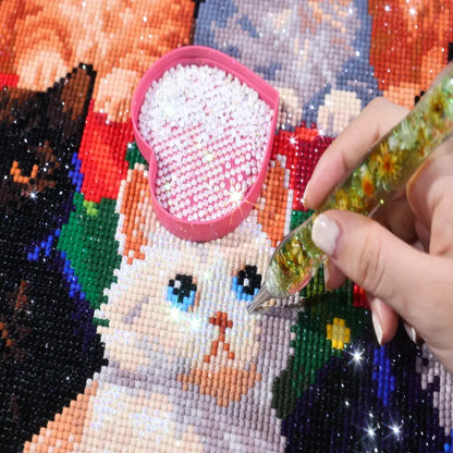 AB diamonds on the Kitten Christmas Tree diamond painting with a hand placing diamonds and an AB diamond tray - FEELOOK Art
