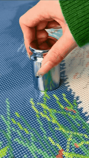 Hand pressing a metal weight onto diamond painting canvas to test adhesive strength, showing firm grip, precise placement, and no slipping during use - FEELOOK Art