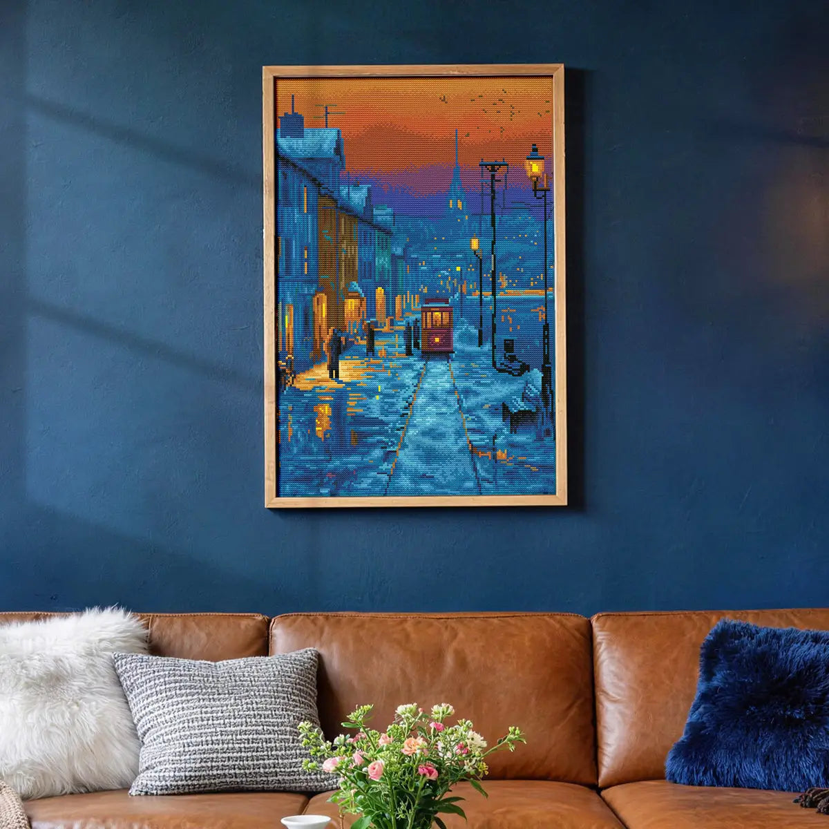 Snowy Street diamond painting displayed on a dark blue wall above a brown leather sofa - FEELOOK Art