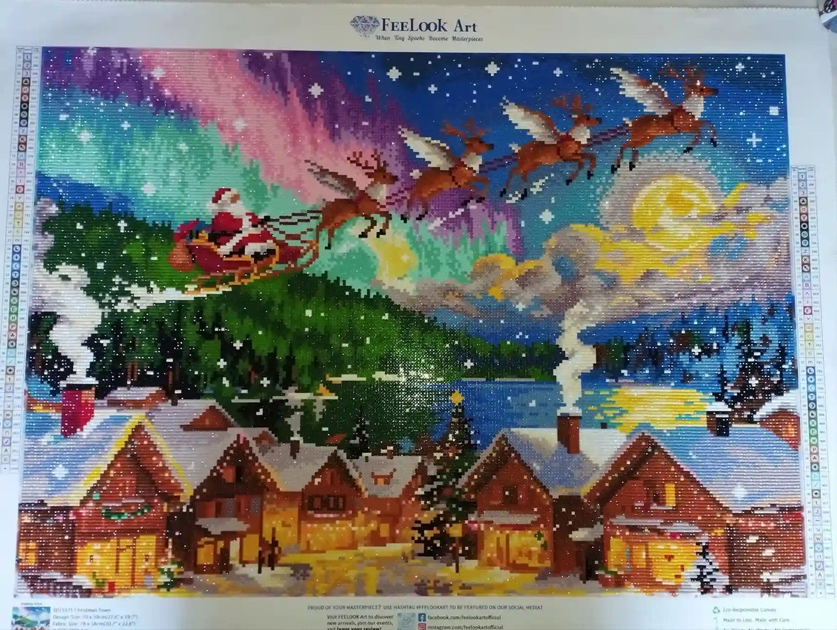 Customer finished diamond painting of Christmas village scene with Santa sleigh, snowy houses and colorful glowing night details - FEELOOK Art