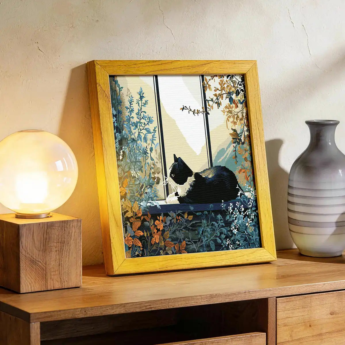 Window Chill diamond painting displayed on a wooden cabinet with a lamp and vase - FEELOOK Art